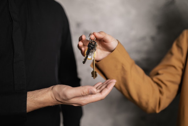 person passing house keys over to another person